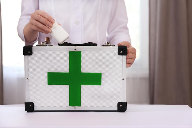 L'infirmière tient une trousse de premiers soins dans la pièce.