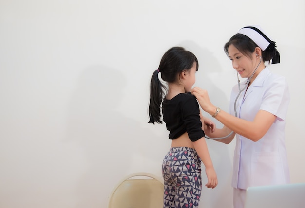 Photo infirmière vérifier coeur de la jeune fille avec stéthoscope