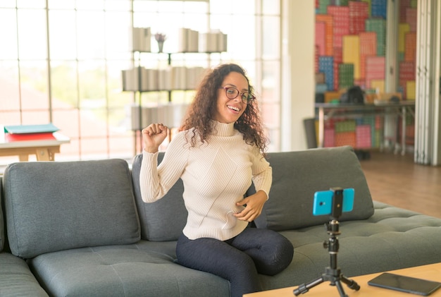 Influenceuse latine filmant une vidéo et parlant avec une caméra pour un blog - concept de contenu en ligne