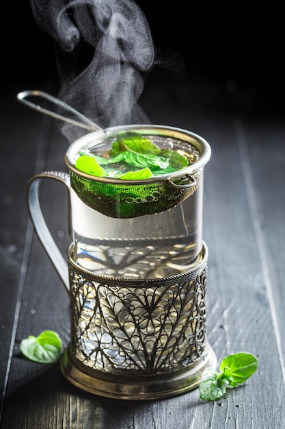 Infuser du thé vert frais sur une vieille table noire