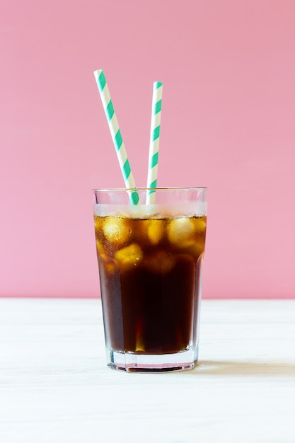 Infusion froide. Café avec de la glace et des pailles à rayures dans un verre