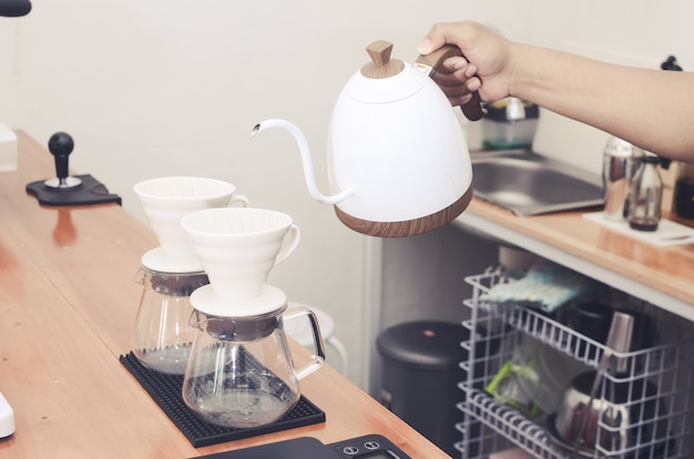 Infusion goutte à goutte, café filtré ou verser avec des croissants sur une table en bois