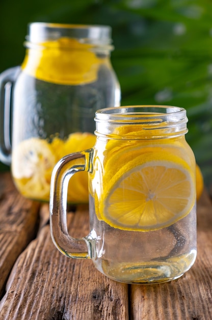 Infusion rafraîchissante de citron CloseUp d'un verre d'eau avec des tranches de citron frais sur une table en 4k