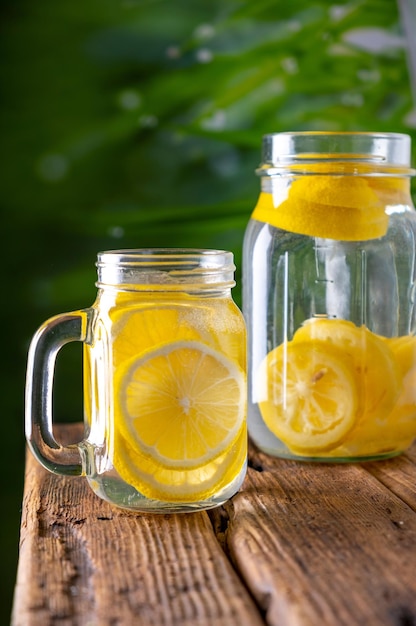 Infusion rafraîchissante de citron CloseUp d'un verre d'eau avec des tranches de citron frais sur une table en 4k