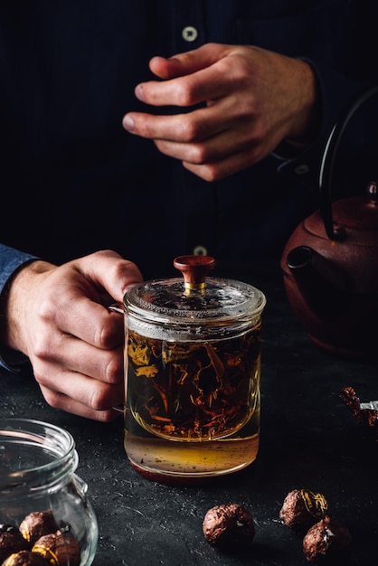 Infusion de thé rouge dans une tasse en verre avec capuchon