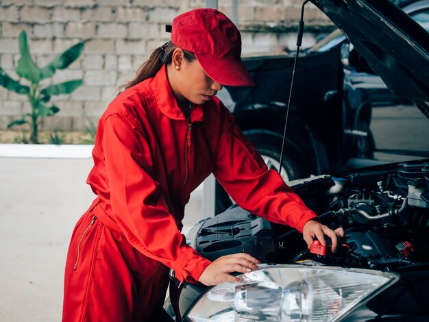 Ingénierie asiatiques femme fixant la voiture.