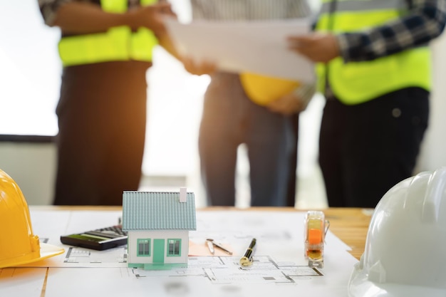 Ingénierie et entrepreneur portant un casque de sécurité sur un chantier de construction tenant un plan dans sa main