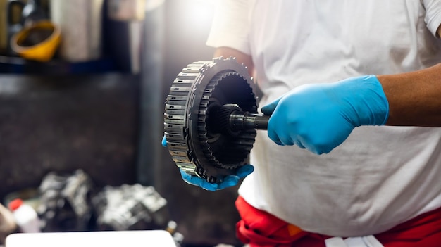 Ingénierie mécanique masculine senior asiatique travaillant sur le véhicule dans le service de réparation de voitures spécialiste de la maintenance technique Propriétaire de petite entreprise