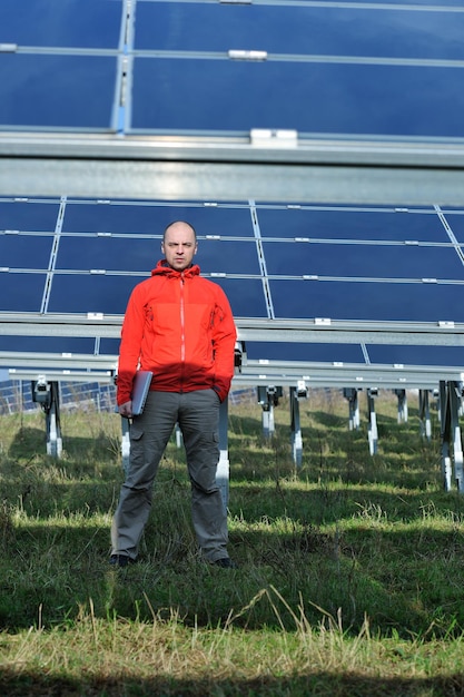 ingénieur d'affaires utilisant un ordinateur portable à l'usine de panneaux solaires champ d'énergie écologique en arrière-plan