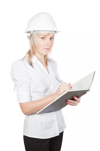 Ingénieur architecte de belle fille prend des notes. Sur un mur blanc.