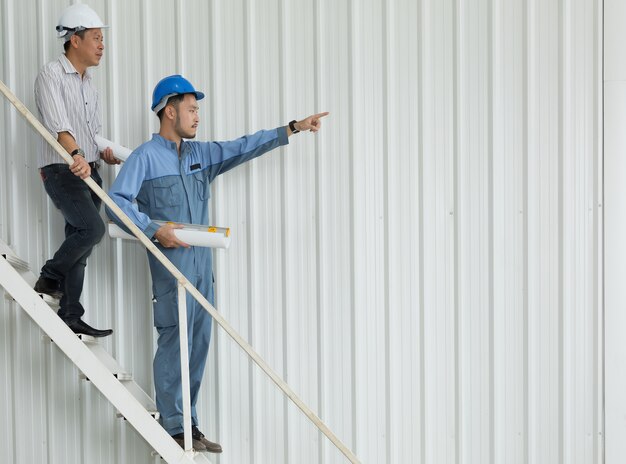 Ingénieur et architectes pointant vers la structure du bâtiment