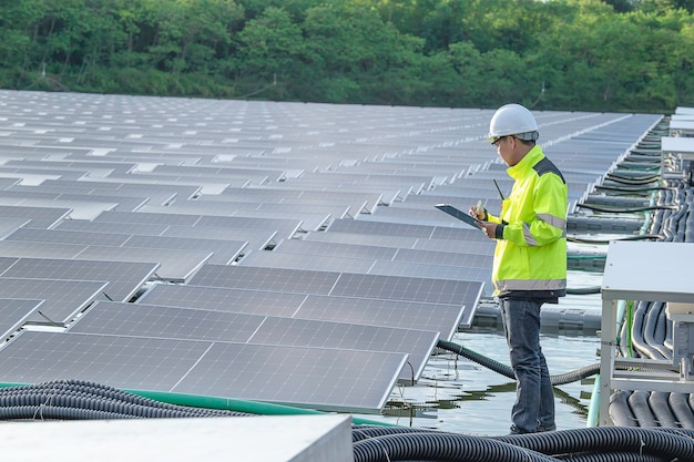 Ingénieur asiatique travaillant à la centrale solaire flottanteÉnergie renouvelableTechnicien et investisseur panneaux solaires vérifiant les panneaux à l'installation d'énergie solaire