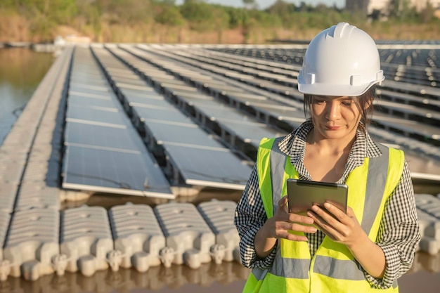 Ingénieur asiatique travaillant à la ferme solaire flottanteÉnergie renouvelableTechnicien et investisseur panneaux solaires vérifiant les panneaux à l'installation d'énergie solaire