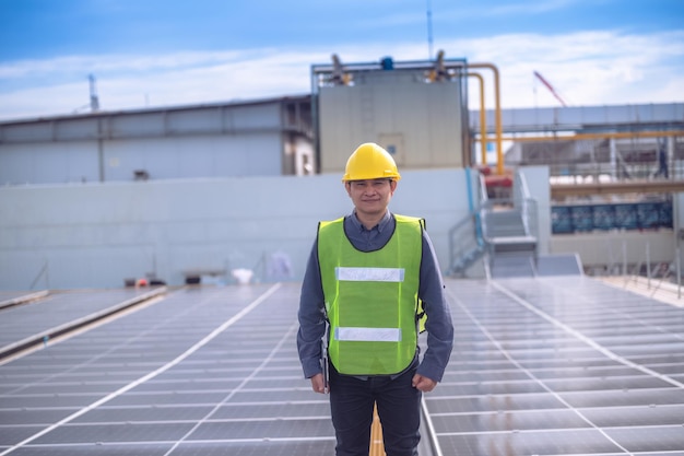 Ingénieur asiatique vérifiant l'énergie des cellules solaires sur le toit de l'usine Ouvrier asiatique travaillant à installer un système de cellules solaires à énergie solaire pour utiliser l'énergie solaire propre