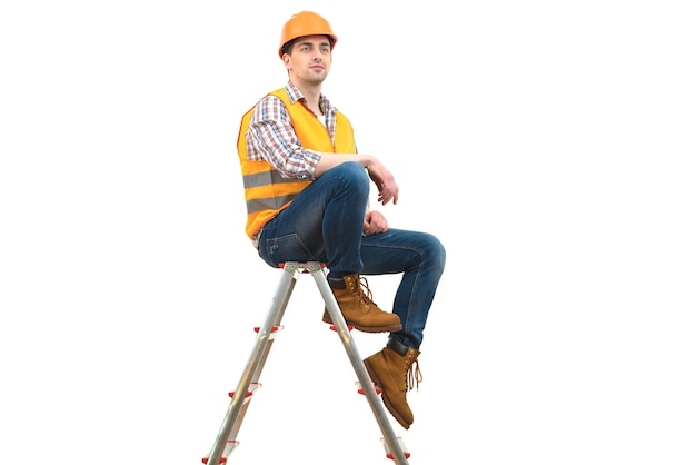 L'ingénieur en casque assis sur l'échelle sur fond blanc