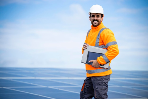 ingénieur de centrale solaire avec ordinateur portable contrôlant la production d'énergie durable