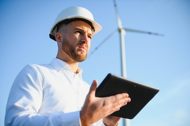 Ingénieur en champ de blé vérifiant la production de turbines