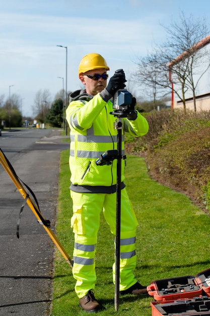 Photo ingénieur de chantier vérifiant les niveaux de la route à l'aide de l'autolevel