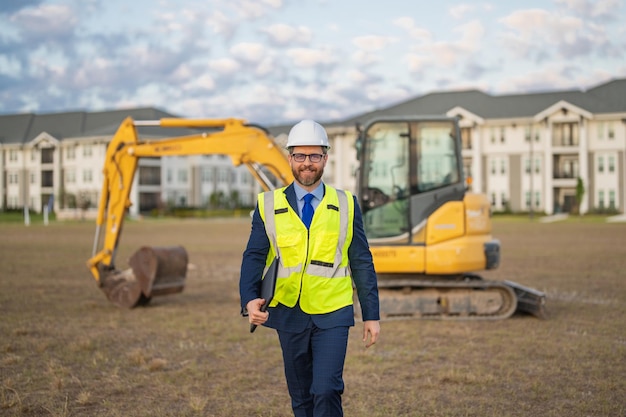 Ingénieur civil sur un chantier de construction, ingénieur mature, homme en costume et casque de sécurité