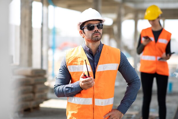 L'ingénieur civil du Moyen-Orient exploite le travailleur à la radio pour contrôler le travail sur le chantier de construction.