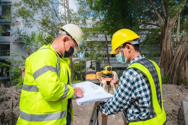 L'ingénieur civil de l'équipe d'enquête travaille à l'aide d'un télescope d'enquête sur le chantier de construction. Utilisation d'un télescope d'arpentage pour les travaux de construction sur les chantiers de construction. Ingénieur civil à l'aide d'un télescope à l'enquête.