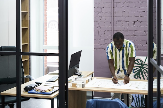 Ingénieur en construction dessinant un plan au bureau