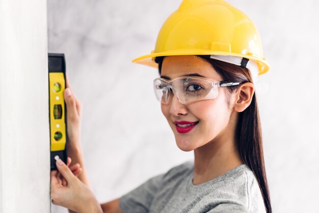 Ingénieur en construction femme en casque jaune travaillant et prenant des mesures