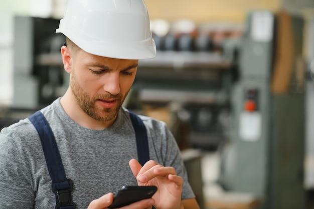 Ingénieur ou contremaître de l'équipe de direction Contrôle permanent des informations sur la gestion de la production industrielle au sein de l'usine par téléphone Concept de travail d'équipe