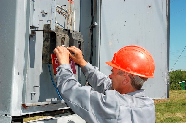 Un ingénieur électricien coupe la tension dans l'armoire de commande électrique.