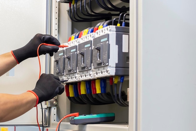 Ingénieur électricien teste une installation électrique avec un multimètre