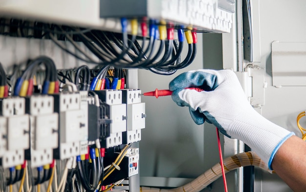 Photo ingénieur électricien vérifiant le fonctionnement de l'armoire de commande électrique, concept de maintenance.