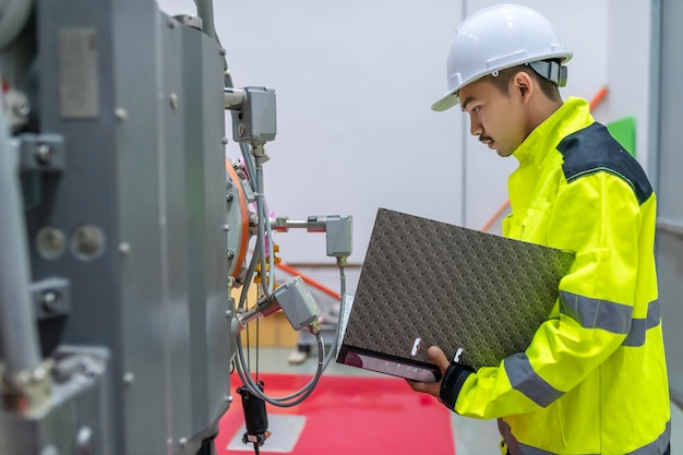 Ingénieur électricien vérifiant la tension à l'armoire de distribution électrique dans la salle de contrôlemaintenance préventive