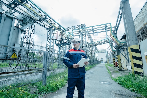 Un ingénieur en énergie inspecte l'équipement moderne d'une sous-station électrique avant la mise en service Énergie et industrie Réparation programmée d'équipements électriques