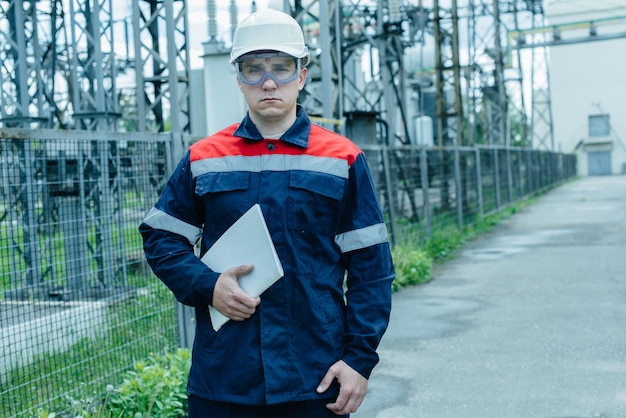 Un ingénieur en énergie inspecte l'équipement moderne d'une sous-station électrique avant la mise en service Énergie et industrie Réparation programmée d'équipements électriques