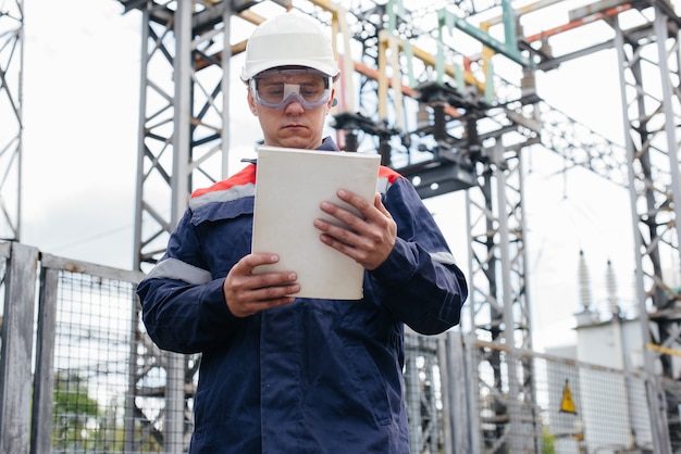 L'ingénieur en énergie inspecte l'équipement de la sous-station. Ingénierie électrique. Industrie.