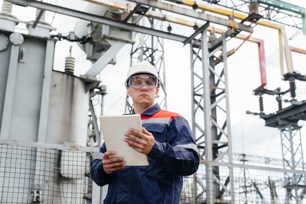 L'ingénieur en énergie inspecte l'équipement de la sous-station. Ingénierie électrique. Industrie.