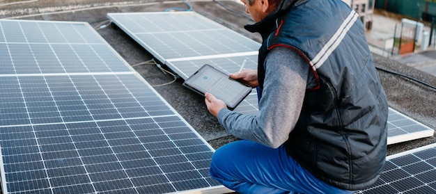Ingénieur en énergie solaire à l'aide d'une tablette pour vérifier la centrale électrique Concept écologique du système d'énergie alternative