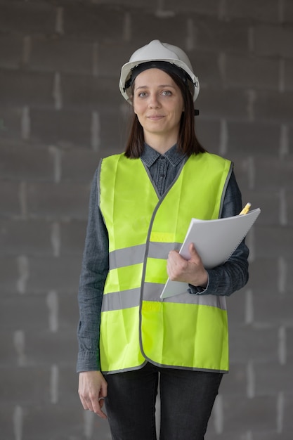 Ingénieur de femme dans un casque blanc et un gilet de sécurité l'ingénieur sur le chantier de construction