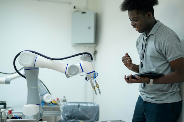 Ingénieur en formation en robotique apprenant à programmer et à manipuler des robots automatiques à main