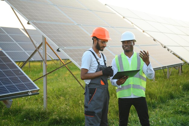 Ingénieur et homme d'affaires planifiant un nouveau projet écologique autour d'un toit à panneaux solaires