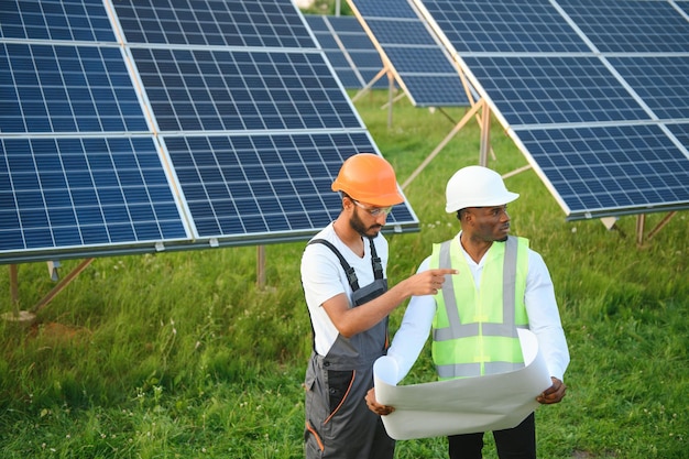 Ingénieur et homme d'affaires planifiant un nouveau projet écologique autour d'un toit à panneaux solaires