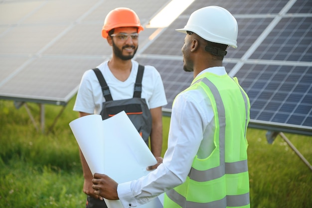 Ingénieur et homme d'affaires planifiant un nouveau projet écologique autour d'un toit à panneaux solaires