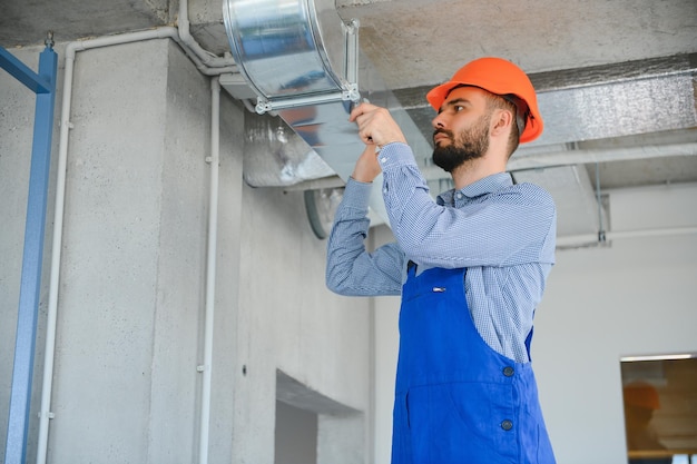 Un ingénieur Hvac installe un système de ventilation à récupération de chaleur pour un nouvel espace de copie de maison