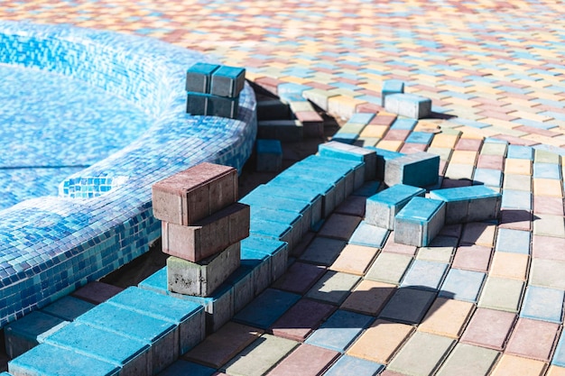 Ingénieur industriel. Carrelage professionnel dans la piscine. Pose de carreaux de piscine en céramique bleue sur sols et murs en béton de ciment.