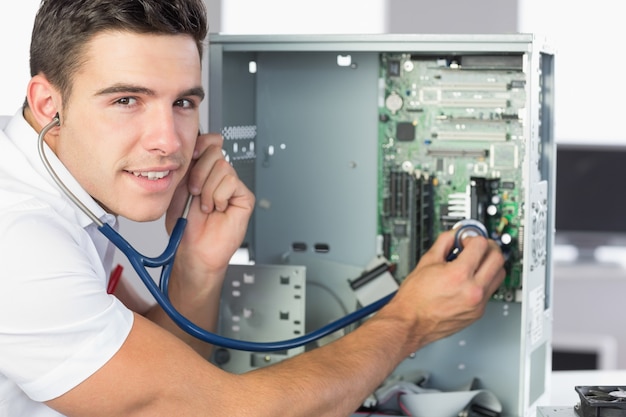 Ingénieur en informatique souriant examinant le matériel avec stéthoscope