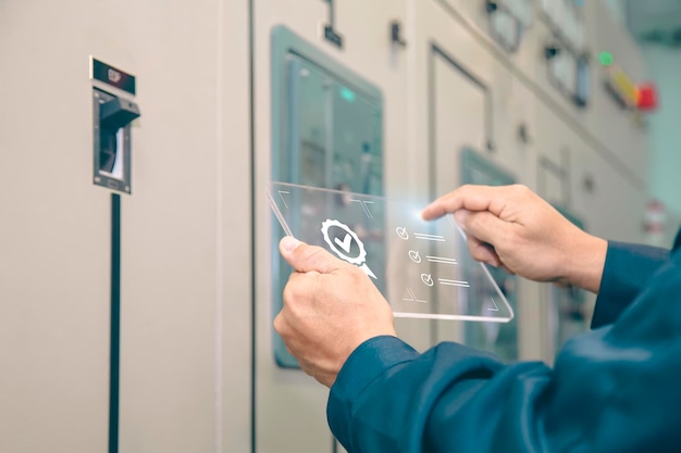 Ingénieur inspectant l'équipement de contrôle haute tension, concept de maintenance.