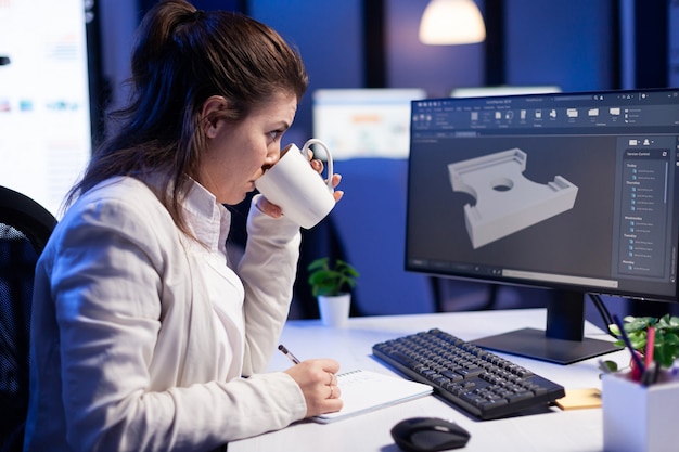 Ingénieur logiciel travaillant sur un projet de CAO numérique tard dans la nuit dans une entreprise de bureau