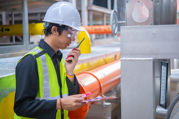 Ingénieur de maintenance asiatique au système de gestion des eaux usées d'une énorme maintenance d'usine vérifiant les données techniques de l'équipement du système de chauffageThaïlandais