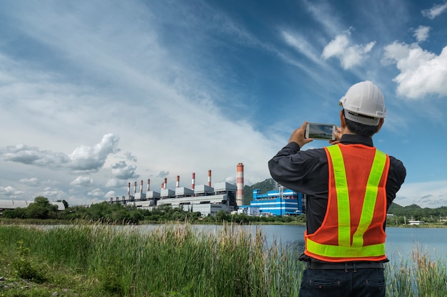 Ingénieur masculin vérifiant et contrôlant avec la centrale électrique au charbon.