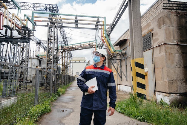 Ingénieur masqué inspecte une sous-station électrique